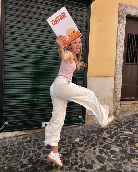 Cliente a mostrar o álbum Qatar numa rua de Lisboa